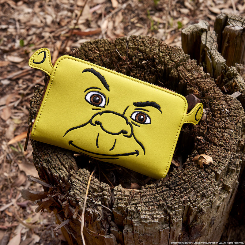 Image of the Loungefly Shrek Keep Out Cosplay Zip Around Wallet sitting on a tree stump outside